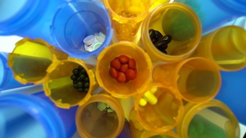 Extreme macro view of pharmaceutical generic prescription drugs and pills bottles on the pharmacy table top. Slow smooth sliding. Pharma companies developing potential coronavirus antiviral concept.