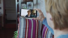 Woman having a video call with child at home. Child smiling and talking. Communication via internet distantly. Video chatting with family.