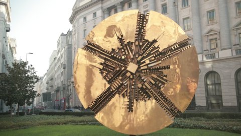 MILAN, ITALY - JAN 1, 2020: Disco, abstract bronze circular sculpture with contemporary value, by Arnaldo Pomodoro on Piazza Meda. Milan, Lombardy, Italy, Europe