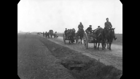 1918 - Families of Belgian farmer refugees make their way back to Ypres on a back road on foot and in horse-drawn carriages.