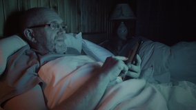 Closeup of senior man yawns while using digital tablet in bed before go to sleep. His wife sleep at background - Powered by Shutterstock - Get 15% off with code: PIKWIZARD15