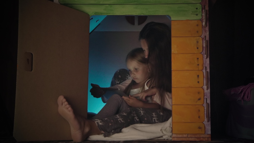 Mother With Her Daughter Using Digital Tablet In Toy House