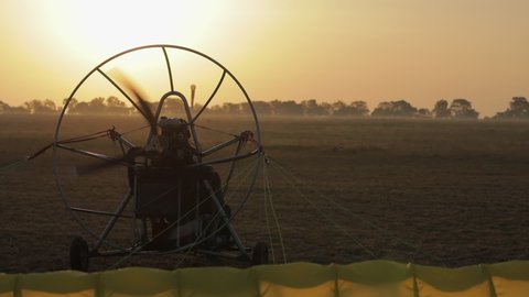 Para motor takes off, sunrise landscape with sunbeams