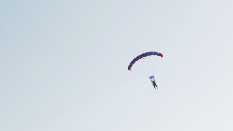 Skydiver in the blue sky in the sun