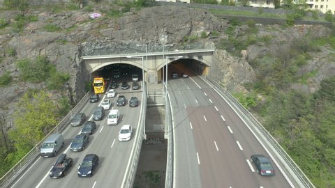 Cars driving in & out of road tunnel. Cars driving in both directions on highway