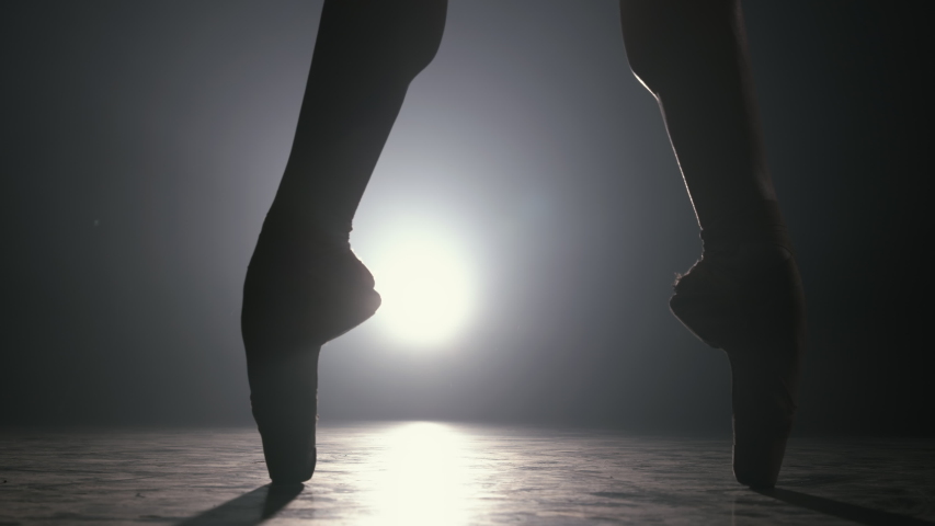 Close up of ballet dancer as she practices exercises on dark stage or studio Royalty-Free Stock Footage #1054832216
