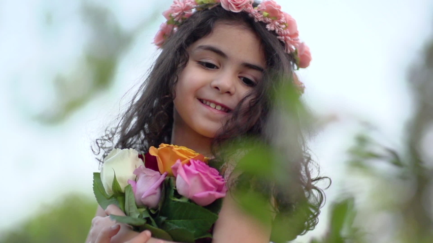 Little cute girl hugs flowers, slow motion