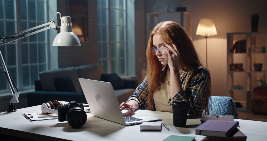 Cute caucasian girl concentrating on work at desk, using laptop to prepare for school or university exam, young freelancing manager working on a project 4k footage Royalty-Free Stock Footage #1054843340