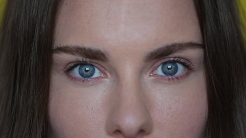 Woman open blue eyes. Close up of female face with wide blue eyes. Brunette woman portrait. Beautiful female macro. Attractive eyes looking camera. Perfect model face