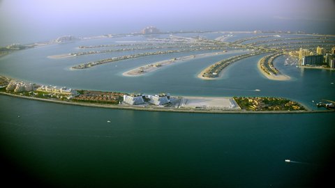 Palm Island in Dubai, aerial view from the side showing half of the island of the Palm. helicopter, 6-axis stabilized gimbal, shootover F1, 8K, zoom in and out, parallax,