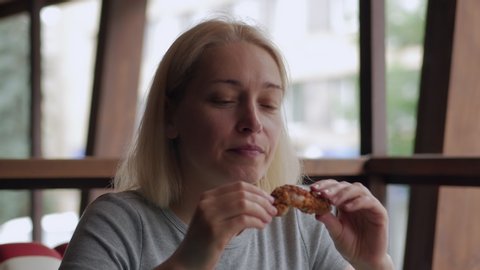 Close-up of a woman's face, eat, fast food, fried chicken wings