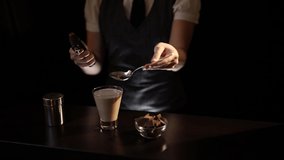 Bartender preparing Baileys comet cocktail, setting it on fire using culinary torch