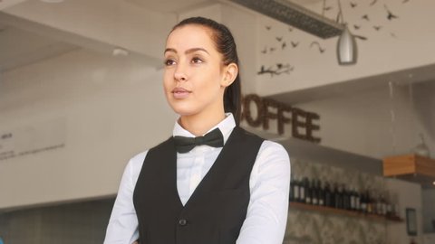 4k medium video of waiter/ hostess welcoming customer and showing them where they will be seated in restaurant. 