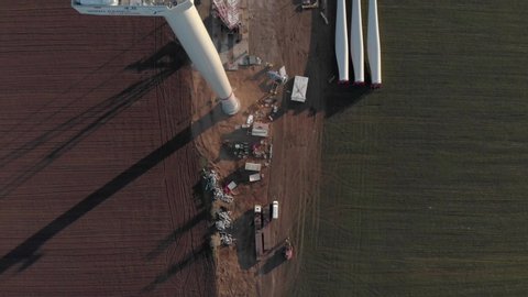 Building process of wind energy power tower mill, under construction. Transportation, installation of rotor. Green, clean, renewable energy. Aerial footage.