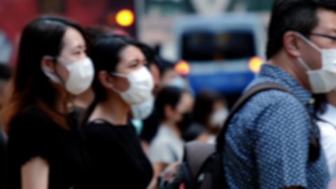 Slow motion of unrecognized people wearing medical face masks in Hong Kong. Coronavirus concept