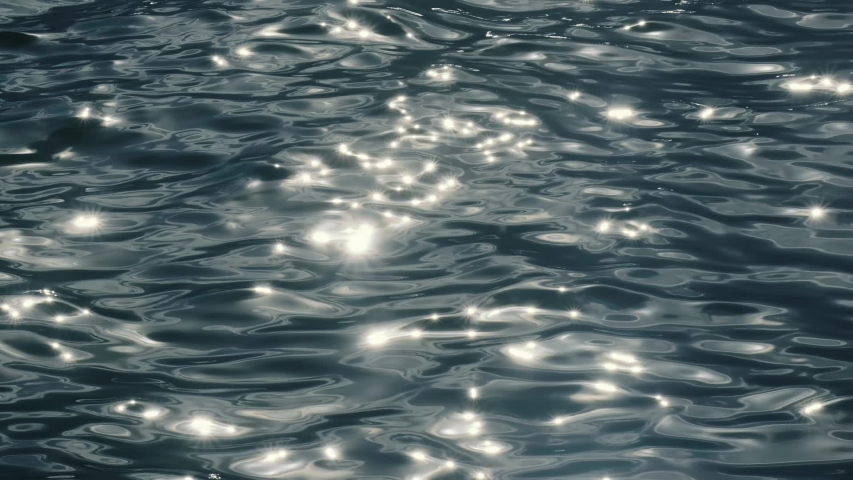 Slow motion of golden glittering sea surface, abstract background.