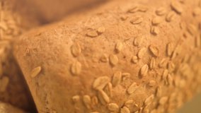 Close-up hd slow motion video. Homemade bread on a rustic background. Fresh Bakery. Bread recently ovened. Vertical format video.