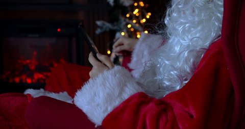Happy reaction of Santa Claus using a mobile phone during Christmas time at home 4k slow motion