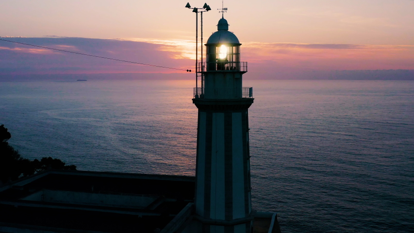 Aerial view of beautiful sunrise behing the dome and light of the lighthouse of the Cape La Nao in Javea, Spain.