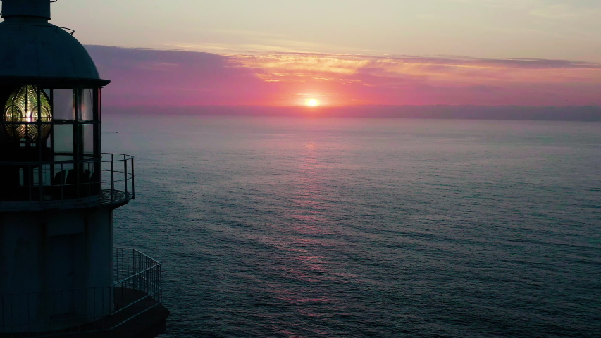 Aerial view of beautiful sunrise behing the dome and light of the lighthouse of the Cape La Nao in Javea, Spain.