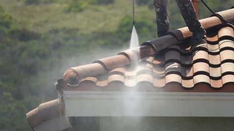 Pressure-washing a roof, medium close up of high power spray