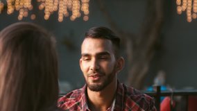 4k medium video of middle eastern man kissing the hand of a happy and romantic woman on date in cafe. 