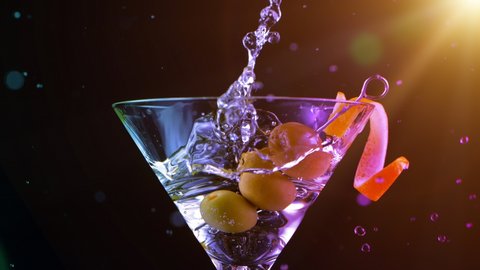 Super Slow motion shot of olives splashing into Dry Martini Drink