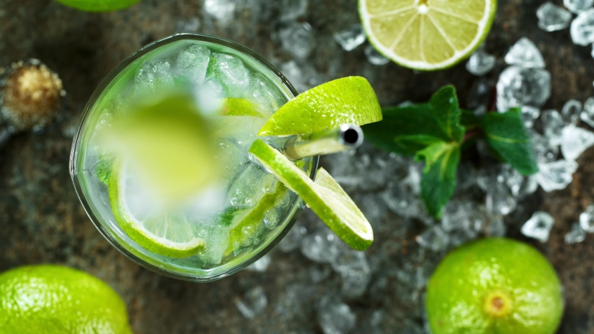 Refreshing mojito cocktail in a glass on black stone table, macro super slow motion filmed on high speed cinematic camera.
