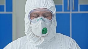 focus pull of scientist in hazmat suit holding test tube with liquid