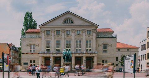 Weimar, Germany - June 17, 2020: Time Lapse of the famous German National Theater in Weimar (Deutsche Nationaltheater Weimar) with the monument of Goethe and Schiller.