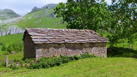 Spring landscape of mountains, mowing meadows and pasiega cabins in the Miera Valley. Cantabria, Spain, Europe