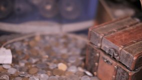 Finger opening treasure chest with coins close up