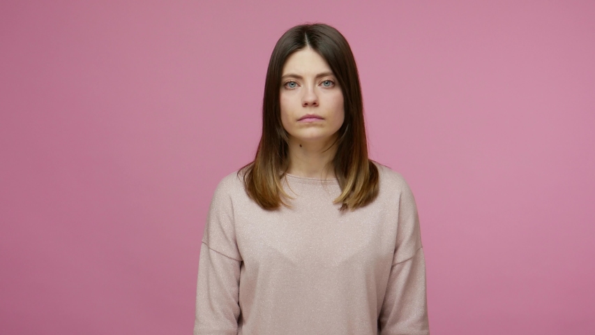 Facepalm, sorrow emotions. Upset worried brunette woman slapping hand on face and expressing regret, blaming herself for troubles, feeling helpless. indoor studio shot isolated on pink background Royalty-Free Stock Footage #1054912592