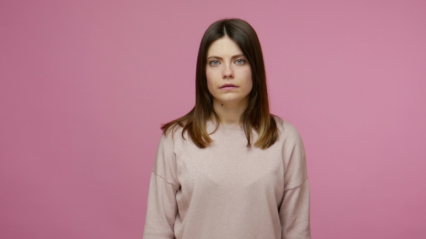 Repulsion to bad smell. Brunette girl grabbing nose with fingers, holding breath to avoid stink, awful fart gases, intolerable odor, showing stop gesture. studio shot isolated on pink background Royalty-Free Stock Footage #1054912610