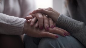 Young adult woman daughter holds elderly mother by the hand. Helping old people, supporting in difficulties, mutual assistance concept. - Powered by Shutterstock - Get 15% off with code: PIKWIZARD15