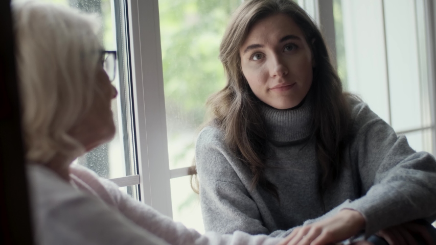 Young woman daughter visiting an elderly mother leads a conversation solving problems. Consulting with elders. Female conversation of people of different generations. Support concept, giving love care Royalty-Free Stock Footage #1054913948