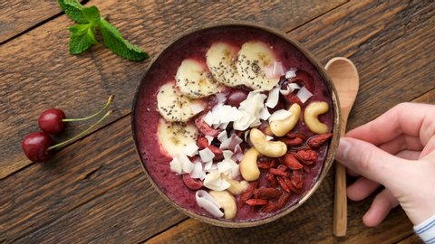 Raw Acai Superfood Smoothie Bowl With Toppings In Coconut Bowl. Top View, Wooden Background, 4K Resolution