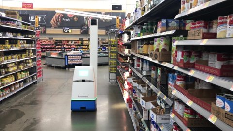 Somerdale, New Jersey - December, 2019: A robot rolls down an aisle and turns as it shines a light on shelves while taking product inventory in a  Walmart store