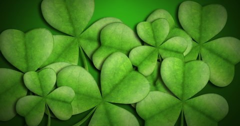 Animation of St Patricks Day multiple light and dark green shamrocks clover leaves on gradient green background. Celebration of Irish culture concept digitally generated image. 4k Stock-video