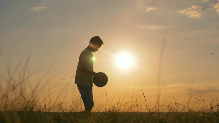 Happy boy with soccer ball. Kid dreams of sports. Silhouette of child in park with soccer ball. Happy child is dreaming with ball in park. Silhouette of boy in park. Happy boy with soccer ball | Shutterstock HD Video #1054920803