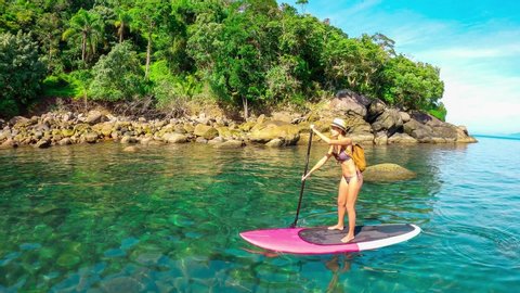Tropical beach, crystal water reef  on Stand Up Paddle Board Woman on Water, Slow Motion Sea, SUP girl, paddle surf.