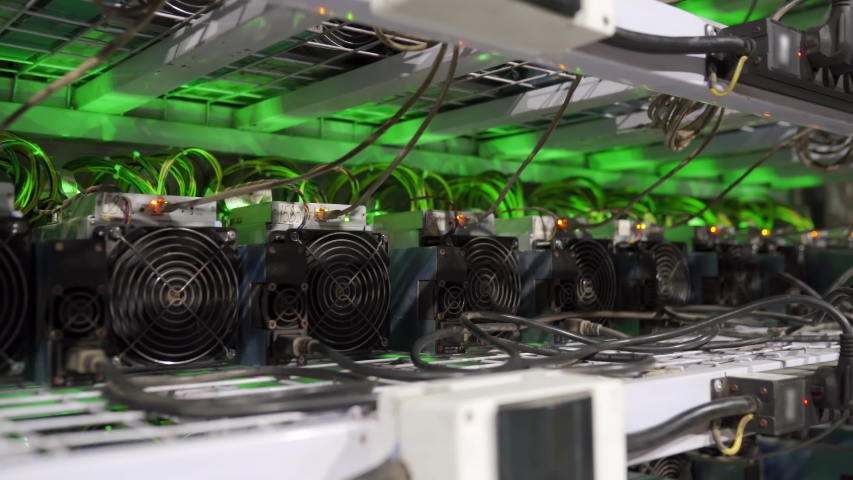 Cryptocurrency mining equipment on large farm.  miners on stand racks mine bitcoin in server room. Blockchain techology application specific integrated circuit. Slider camera. | Shutterstock HD Video #1054927268