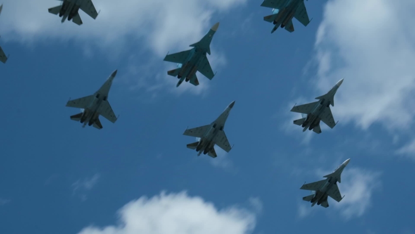 Column military warplanes flies over the ground in honor of the victory parade . Military planes in a beautiful blue sky. Air force parade. Royalty-Free Stock Footage #1054928243