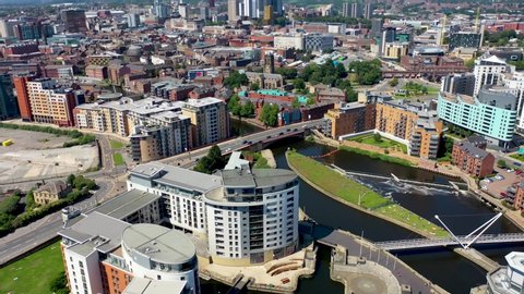 Aerial drone footage of the area in the Leeds City Centre known as The Leeds Dock, showing apartments and buildings along side the River Aire and canal on a bright sunny summers day