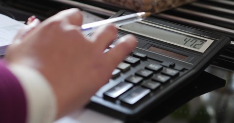 Close Up And Rack Focus Of Female Bookkeeper Using Calculator