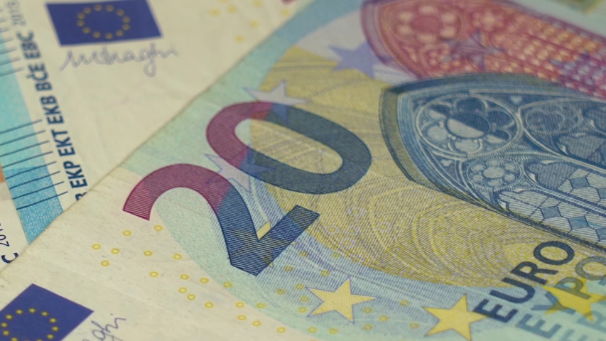 Closeup view video footage of several banknotes of paper Euro money isolated on white wooden table background. Person counts pink and blue 10 and 20 paper banknotes of euros money. Royalty-Free Stock Footage #1054935893