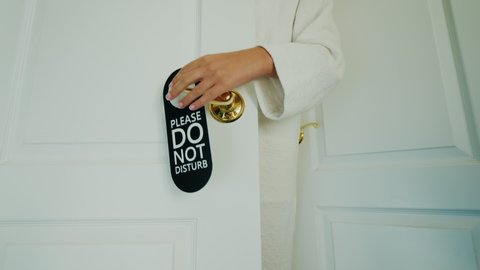 A woman refuses to clean the room, hangs a Do Not Disturb sign on the door