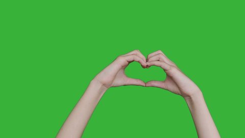 4K footage real time close-up hand of asian young girl making a heart shape isolated on chroma key green screen background.
