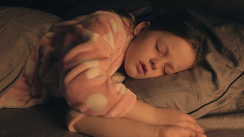 Sleeping kid. Carefree childhood. Relaxed girl seeing sweet dreams in bed with eyes closed at night.