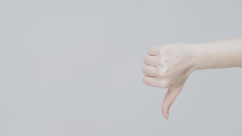 Hand gestures. Approval dislike. Woman showing thumb up down isolated on gray copyspace background.